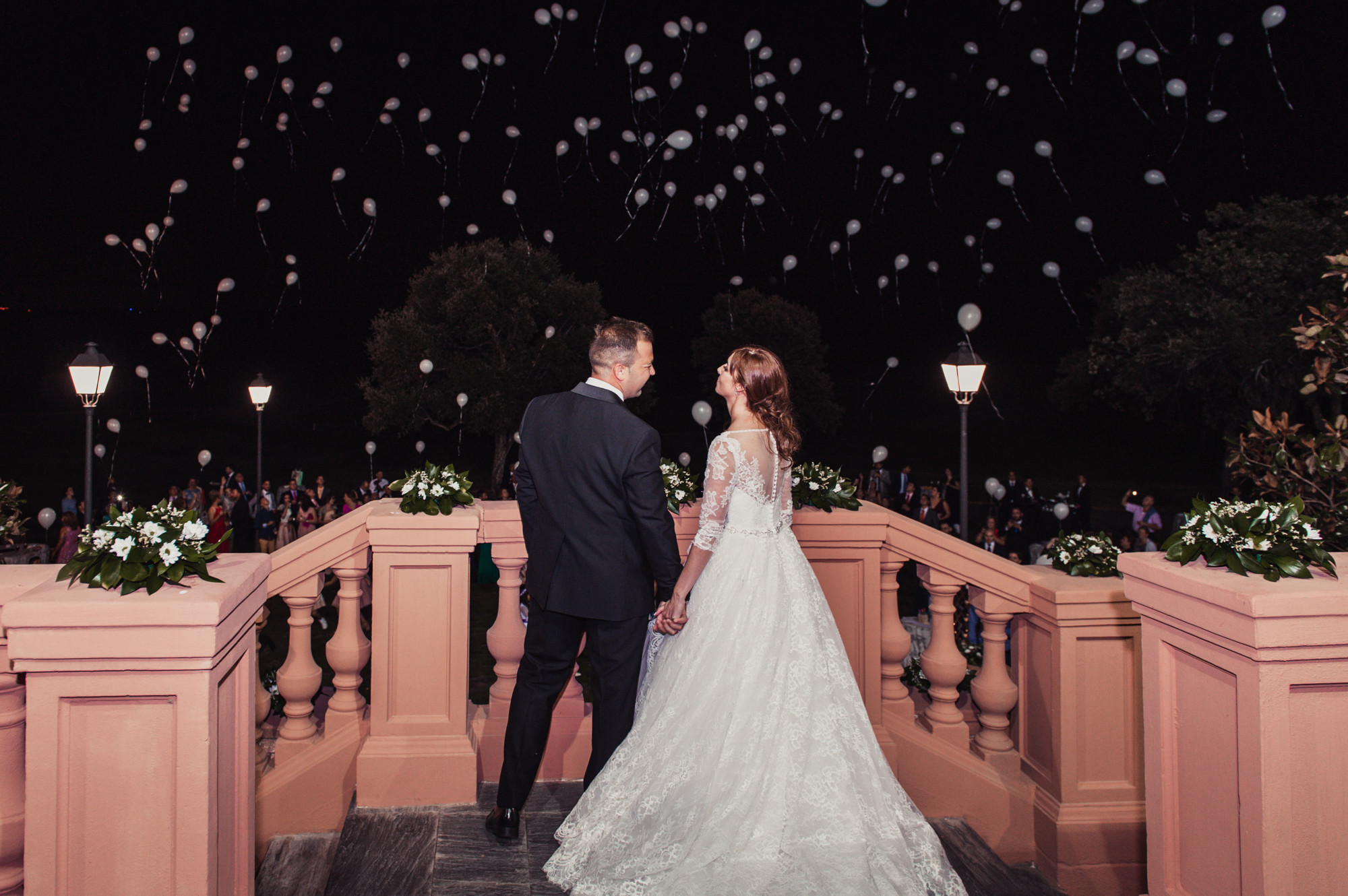 novios mirando al cielo de noche con globos